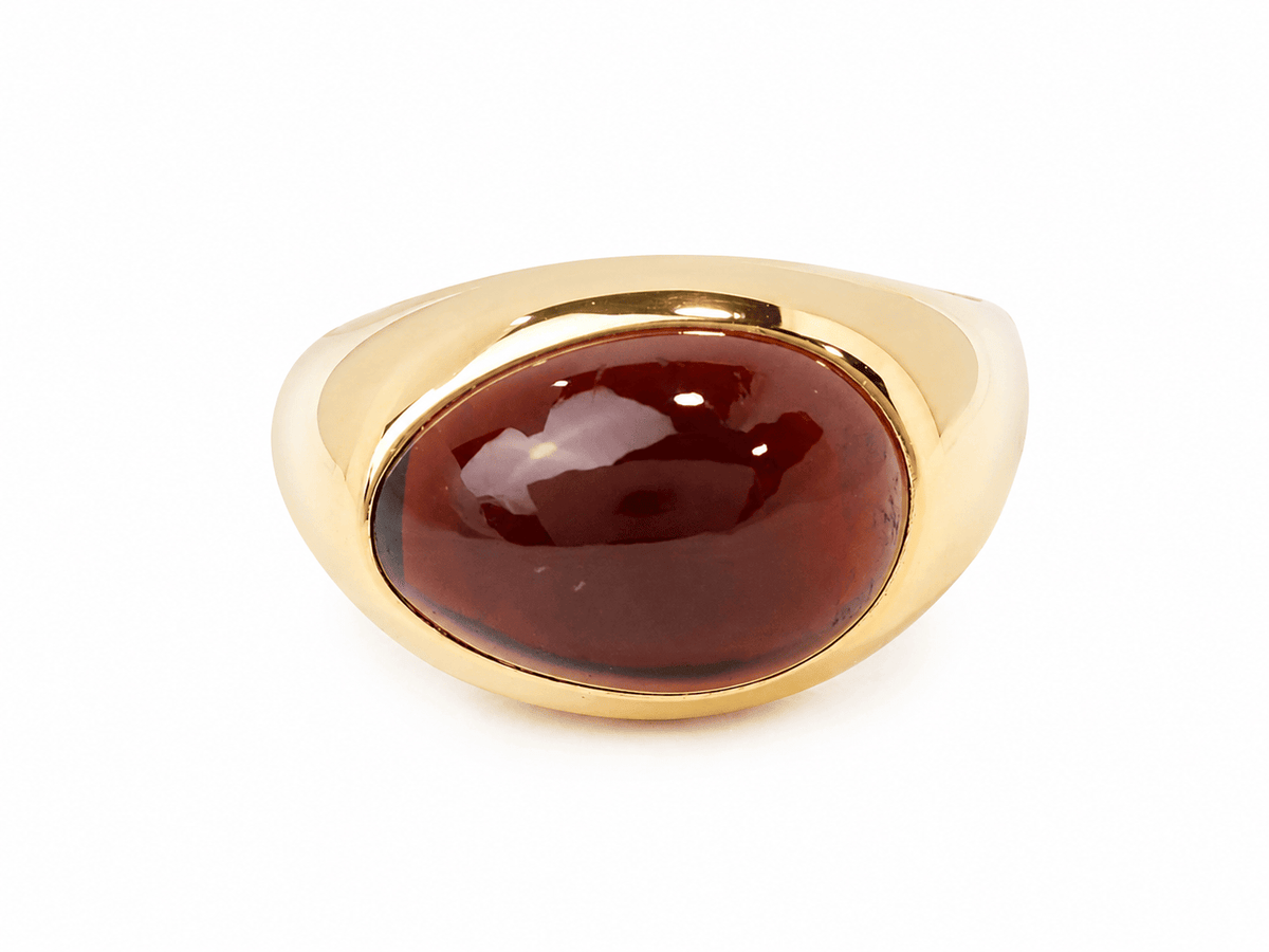 Bague vintage L'Aurore Pomellato en or jaune 18 carats ornée d'un grenat cabochon rouge profond