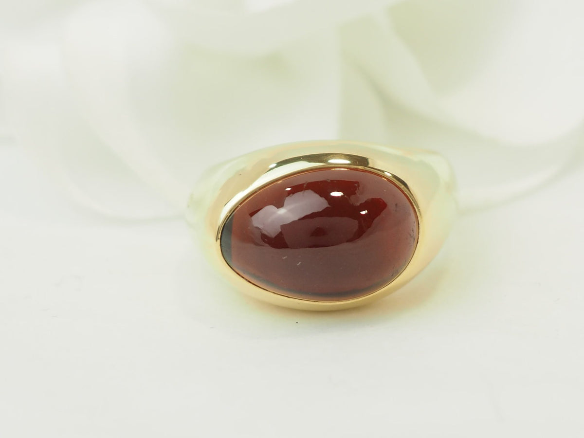Bague vintage L'Aurore Pomellato en or jaune 18 carats avec un grenat taille cabochon profond