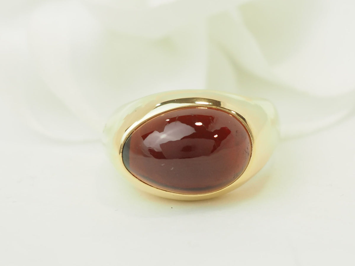 Bague vintage L'Aurore Pomellato en or jaune 18kt avec un grenat cabochon ovale