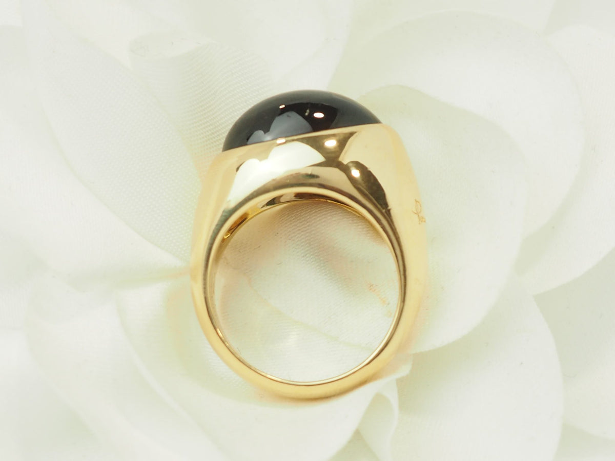 Bague vintage L'Aurore Pomellato en or jaune 18kt avec un grenat cabochon sombre sur fond de pétales blancs
