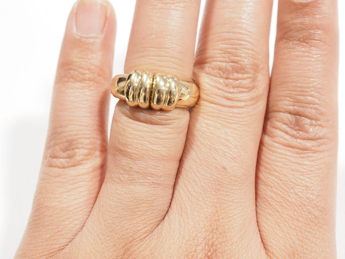 Bague vintage L'Aurore en or jaune 18 carats avec diamants et dessus coulissant portée sur un doigt