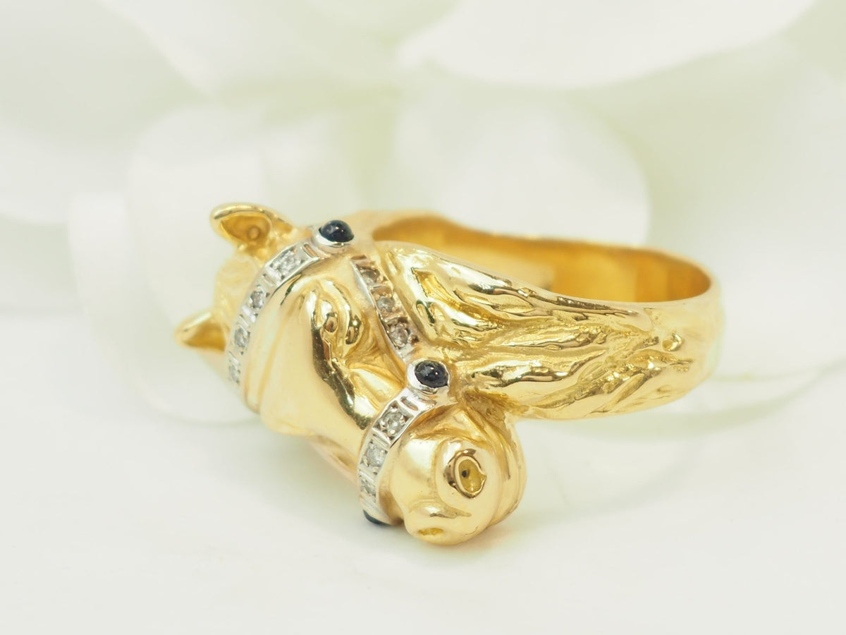 Bague tête de cheval L'Aurore en or jaune 18 carats ornée de diamants et de saphirs sur fond blanc