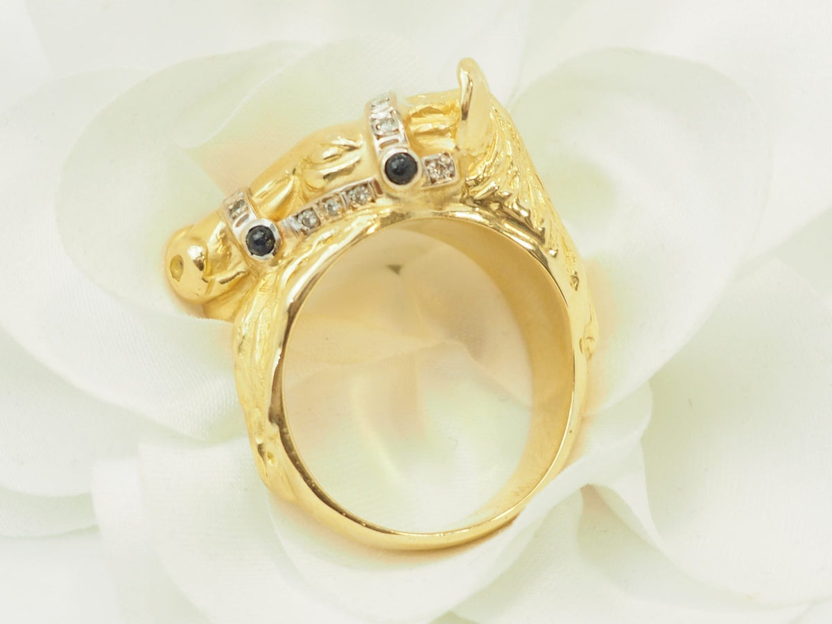 Bague tête de cheval L'Aurore en or jaune 18 carats ornée de diamants et de saphirs sur un fond de pétales blancs