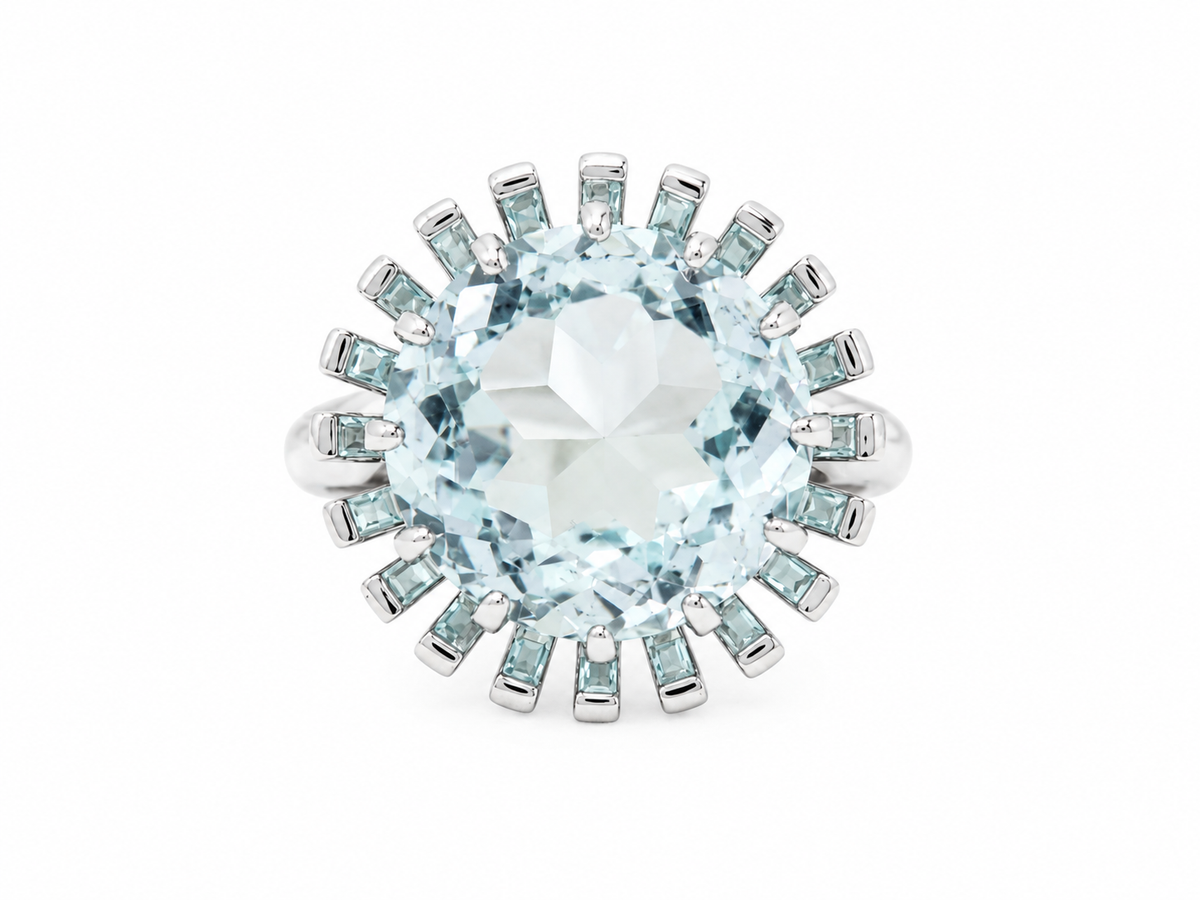 Bague vintage L'Aurore en or blanc 18kt ornée d'une imposante aigue-marine ronde entourée de petites pierres bleues