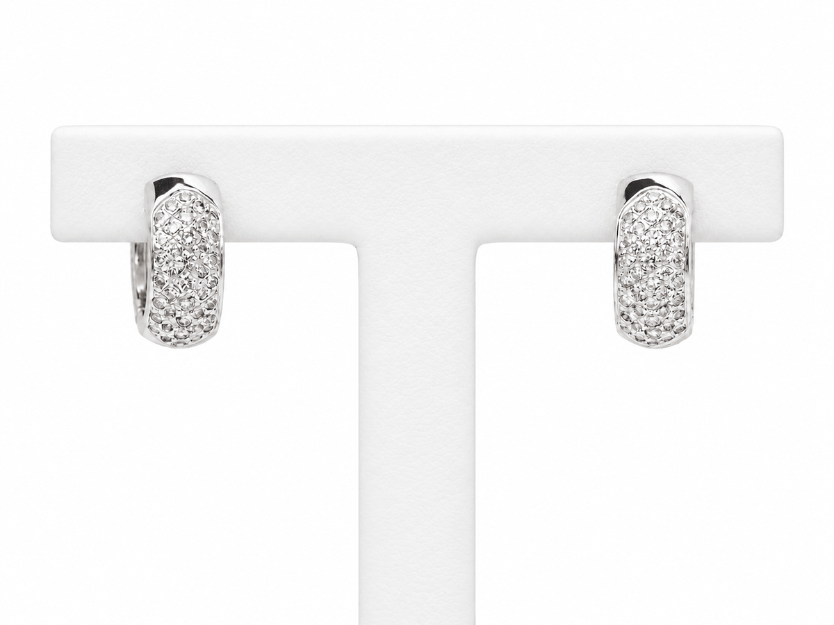 Boucles d'oreilles créoles L'Aurore en or blanc 18 carats pavées de diamants taille brillant sur présentoir blanc