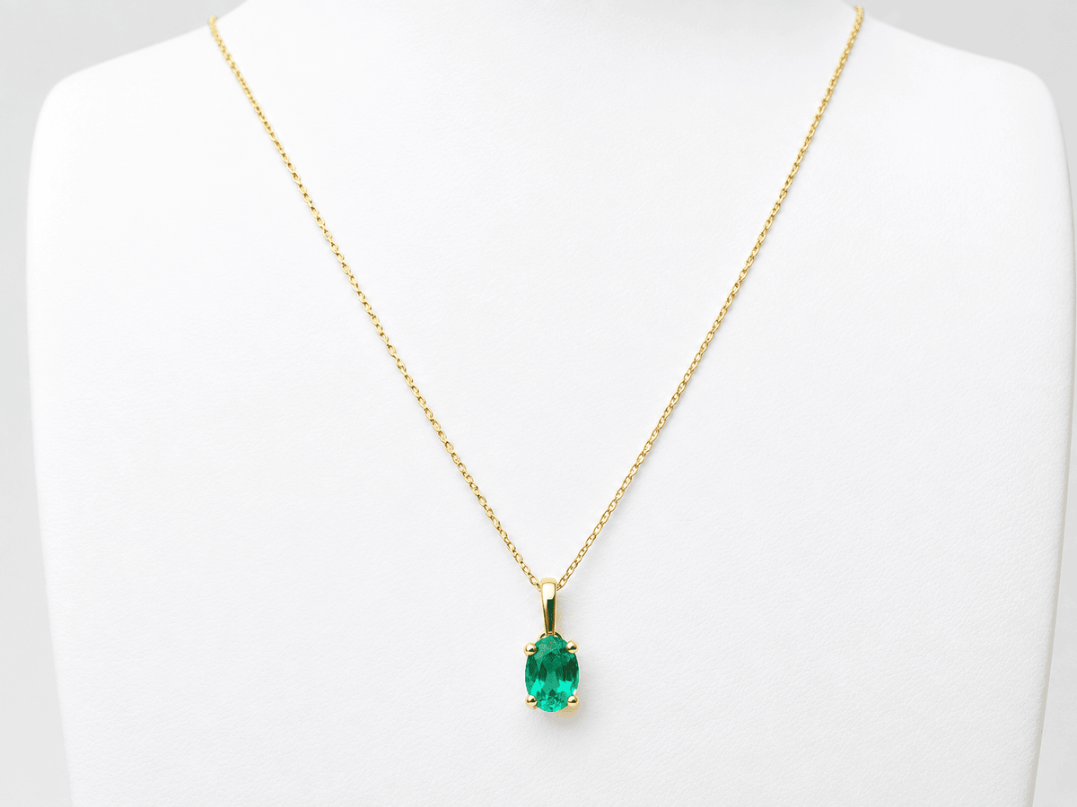 Pendentif L'Aurore en or jaune 18 carats avec une émeraude naturelle ovale de 1,23 carat sur un présentoir blanc