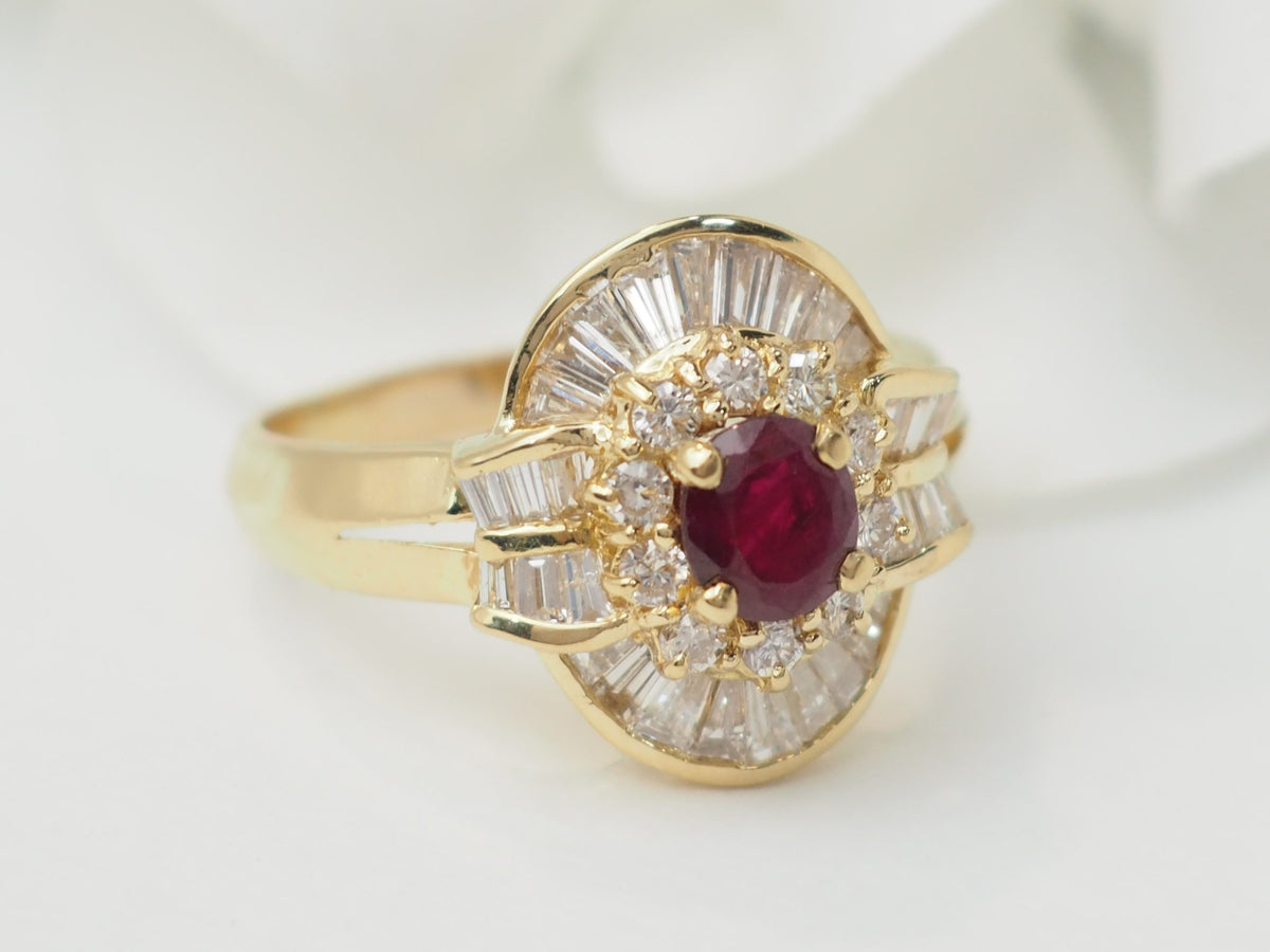Bague jupe vintage L'Aurore en or jaune 18k, ornée d'un rubis central entouré de diamants brillants et baguettes