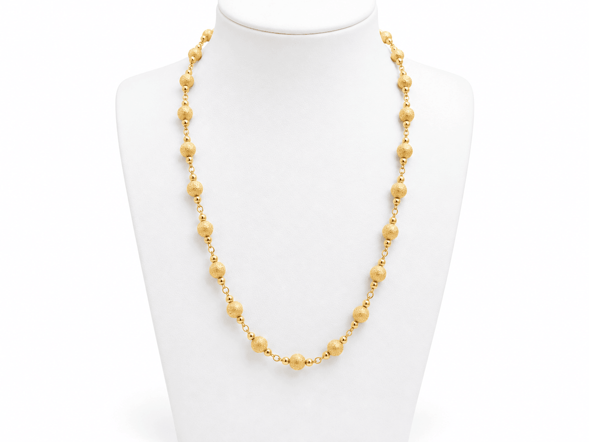 Collier L'Aurore en or jaune 18 carats composé de boules texturées de 6 mm de diamètre sur un buste de présentation