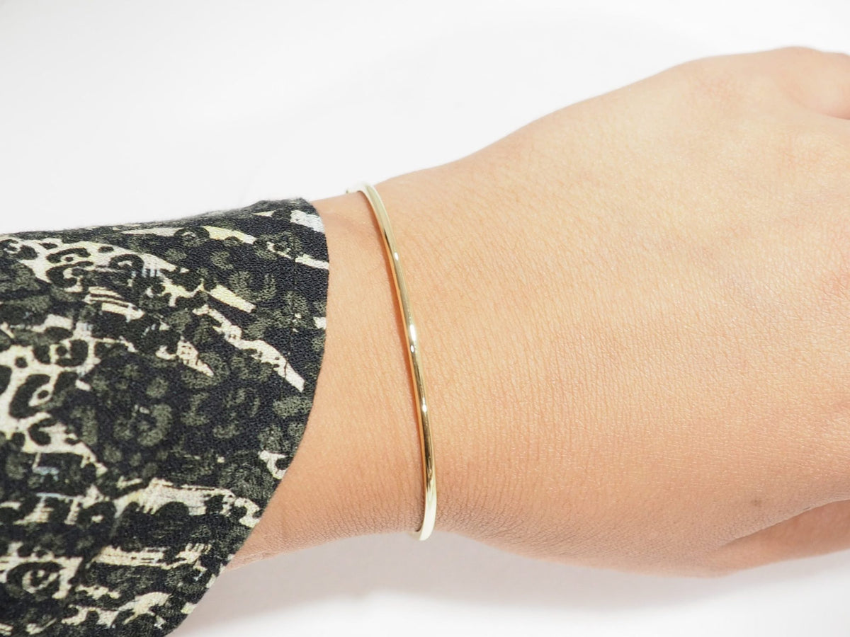 Bracelet jonc flexible L'Aurore en or jaune 18 carats porté au poignet