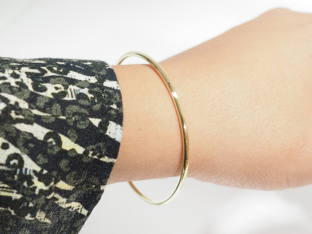 Bracelet jonc flexible L'Aurore en or jaune 18 carats porté au poignet