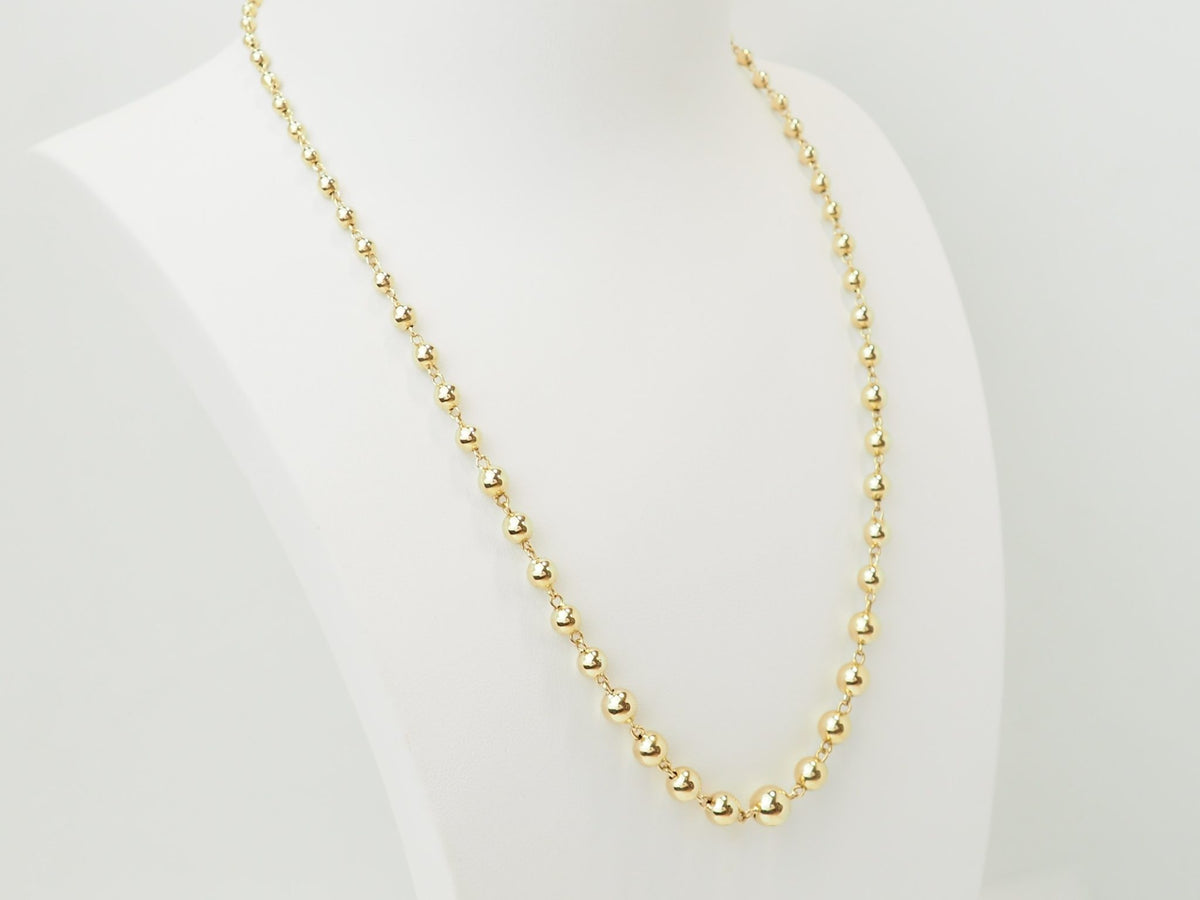 Collier marseillais vintage L'Aurore en or jaune 18 carats avec boules graduées de 2 à 7 mm sur présentoir