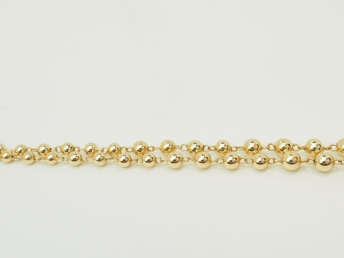 Collier marseillais L'Aurore en or jaune 18 carats composé de boules de tailles dégressives sur fond blanc