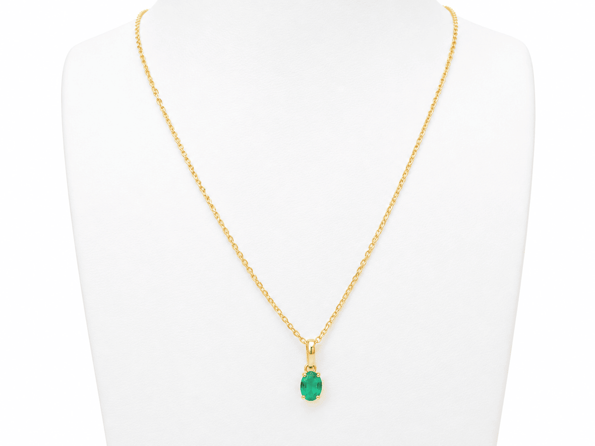 Pendentif L'Aurore en or jaune 18 carats avec une émeraude naturelle ovale de 0,65 carat sur un présentoir blanc