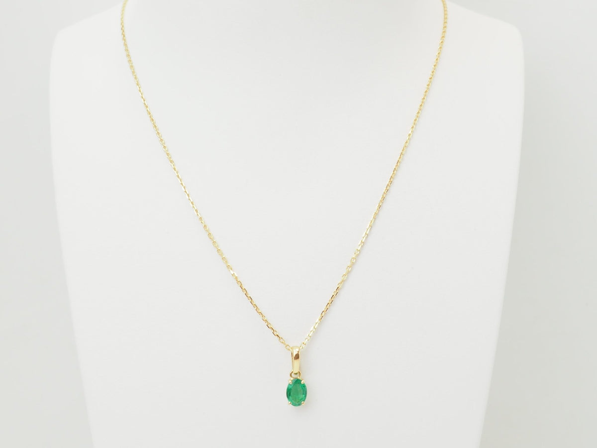 Pendentif L'Aurore en or jaune 18 carats avec une émeraude naturelle ovale de 0,65 carat sur un présentoir blanc
